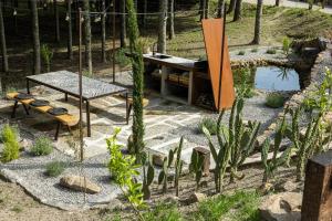 a table and bench in a garden with a pond at Villas Santo António in Baião