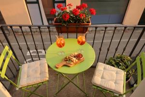 a green table with a plate of food on a balcony at Casa Quadrifoglio - Borromeo in Intra