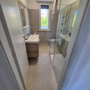 a bathroom with a shower and a sink and a mirror at Appartamento Scossicci in Porto Recanati +23 photos