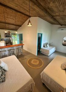 a room with three beds and a bar in it at OCA Caraíva in Caraíva