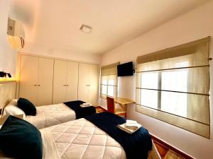 a bedroom with two beds and a window at Hostal J&C in Olula del Río