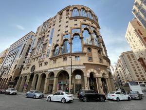 a large building with cars parked in front of it at Al Mukhtara Almasi Hotel - شركة المختارة الماسي للخدمات الفندقيه شخص واحد in Medina