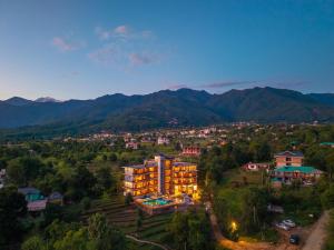 a building in a city with mountains in the background at The Hosteller Bam Bir in Bīr
