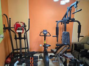 a gym with three exercise bikes and a couch at Rose Petals in Sagana