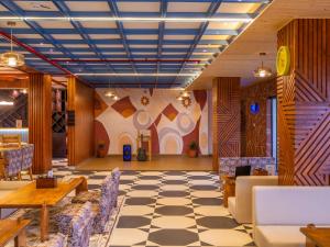 a lobby with a checkered floor and chairs at The Hosteller Bam Bir in Bīr