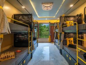 a bus with bunk beds in a room at The Hosteller Bam Bir in Bīr