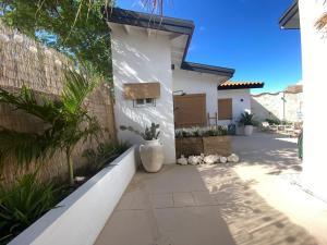 a house with a vase on the side of it at Palm Beach Vacay Suites - Garden Suite - Poolside in Palm-Eagle Beach