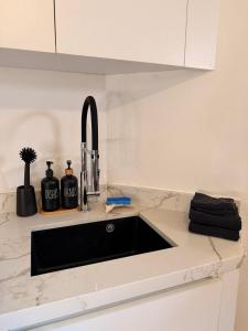 a kitchen counter with a black sink in a kitchen at Palm Beach Vacay Suites - Garden Suite - Poolside in Palm-Eagle Beach +23 photos