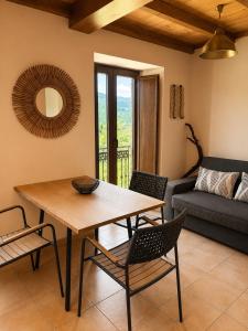 a living room with a table and chairs and a couch at RURAL PRADO in San Tirso de Abres +12 photos
