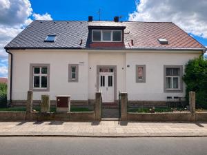 a white house with a fence in front of it at Apartmán Růžovka in Jaroměř