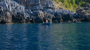 a man is rowing a boat in the water at Romantic Hotel & Restaurant Villa Cheta Elite in Maratea