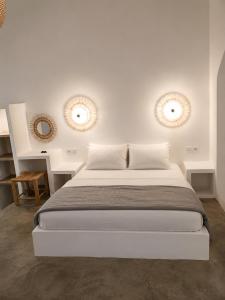 a white bedroom with a bed and two mirrors at Ιόνια Γαλήνη Pool Spa Suite in Parga +29 photos