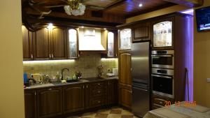 a kitchen with wooden cabinets and a stainless steel refrigerator at POKOJE GOŚCINNE ”ŻUBR” in Białowieża
