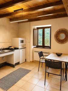 a kitchen and dining room with a table and chairs at RURAL PRADO in San Tirso de Abres