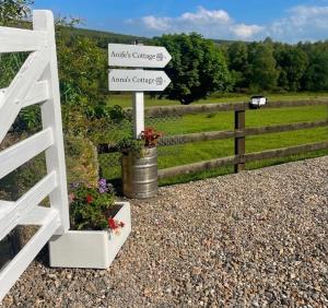 a white fence with signs and a bucket of flowers at Birch Valley Accommodation Tinahely Wicklow in Killicreny Bridge