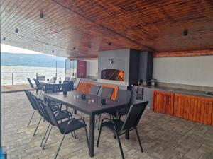 a dining room with tables and chairs and a fireplace at Pensiunea EUPHORIA in Sviniţa
