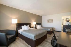 a hotel room with two beds and a chair at Econo Lodge Auburn I-95 in Auburn +21 photos