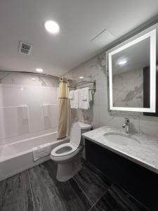 a bathroom with a toilet and a tub and a sink at Wethersfield Motel in Wethersfield +6 photos