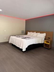 a bedroom with a large bed with a white blanket at Wethersfield Motel in Wethersfield