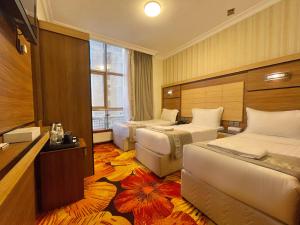 a hotel room with two beds and a television at Al Mukhtara Almasi Hotel - شركة المختارة الماسي للخدمات الفندقيه شخص واحد in Medina