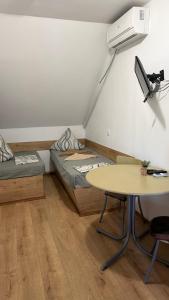a room with two beds and a table and a desk at Мотель Ріта in Berehove