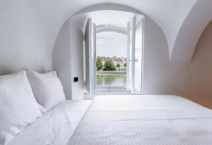 a bedroom with a white bed and an open window at stay micro Regensburg in Regensburg