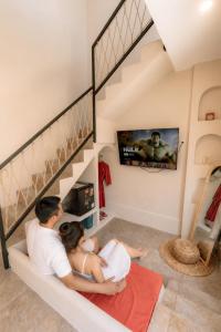 a man and woman sitting on a couch in a living room at Maroko Jogja Villas With Privatepool in Ngaglik