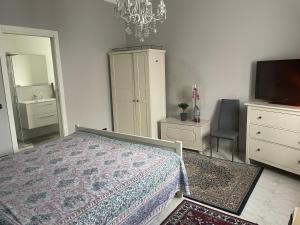 a bedroom with a bed and a dresser and a television at Villa Alessandra in Acqui Terme