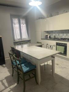 a kitchen with a table and chairs in a room at Villa Alessandra in Acqui Terme