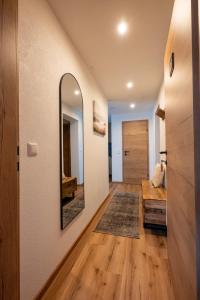 a hallway with a mirror and a wooden floor at Ferienwohnung Tiefengraber in Weiz