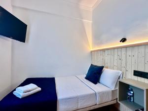 a bedroom with a bed with blue and white pillows at Hostal J&C in Olula del Río +24 photos