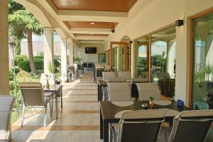 a restaurant with tables and chairs and windows at Hotel Trezor in Varna City