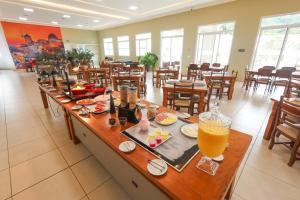 a restaurant with a long table with a drink on it at Grande Hotel Águas da Prata in Águas da Prata