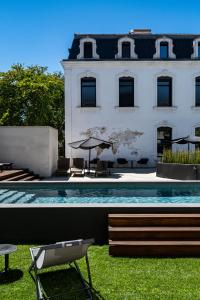 a swimming pool in front of a white building at Hôtel In Situ in Béziers +40 photos