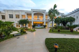 a large building with a courtyard with palm trees at Grande Hotel Águas da Prata in Águas da Prata