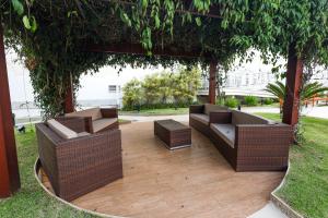 a patio with wicker chairs and tables under a pergola at Grande Hotel Águas da Prata in Águas da Prata