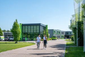 two men walking down a sidewalk in front of a building at Work and Stay in Maasbree
