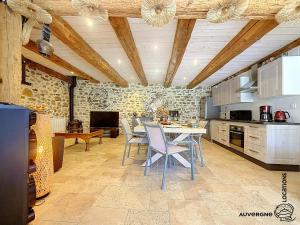 a kitchen with a table and chairs in a room at L'Hirondelle des Sarments in Montaigut-le-Blanc