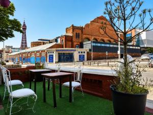 a table and chairs on a patio with a street at Highfield Hotel Blackpool in Blackpool