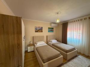 a bedroom with two beds and a window at GRANDPA's HOME in Pusteci