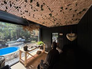 a person sitting in a room with a bath tub at Nest Spa Mirror Villas in Medemciems