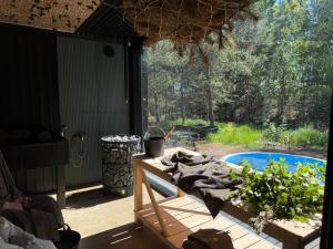 a patio with a table and a swimming pool at Nest Spa Mirror Villas in Medemciems
