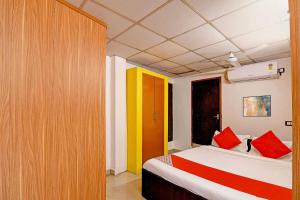 a bedroom with a bed with red and yellow walls at Hotel O Jalan Regency in Kolkata