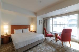 a hotel room with a bed and a table and chairs at JR Kyushu Station Hotel Kokura in Kitakyushu +104 photos