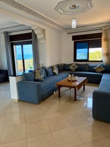a living room with blue couches and a coffee table at Paraiso Costero Azla Tetouan in Azla