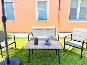 two chairs and a table with flowers on the grass at Padova Cottage in Padova