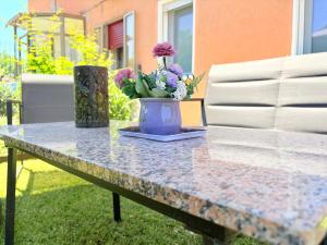 a table with a vase with flowers on it at Padova Cottage in Padova