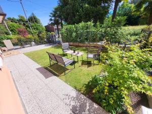 a group of benches sitting in a garden at Padova Cottage in Padova