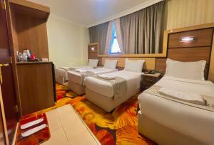 a room with a bunch of beds in it at Al Mukhtara Almasi Hotel - شركة المختارة الماسي للخدمات الفندقيه شخص واحد in Medina