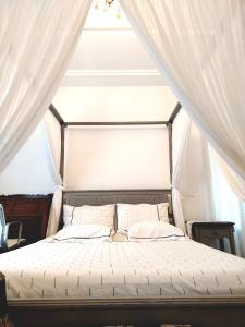 a bedroom with a bed with a canopy at Sainte Madeleine in Boumhel El Bassatine